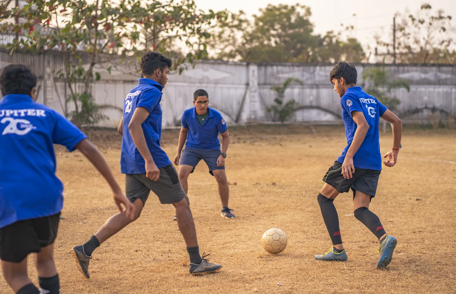 Student forward striking the football on the campus pitch.